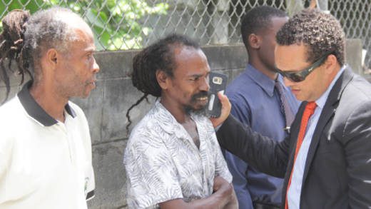 Lawyer Grant Connell, right, speaks with his clients, Alvin Williams, centre, and Irwin Thomas outside the Serious Offences Court on Wednesday. (iWN photo)