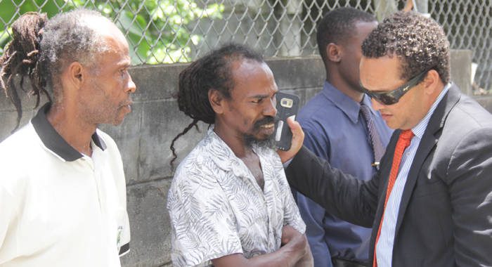 Lawyer Grant Connell, right, speaks with his clients, Alvin Williams, centre, and Irwin Thomas outside the Serious Offences Court on Wednesday. (iWN photo)