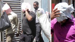 The accused men hide their faces as they are escorted to court on Thursday. (iWN photo)