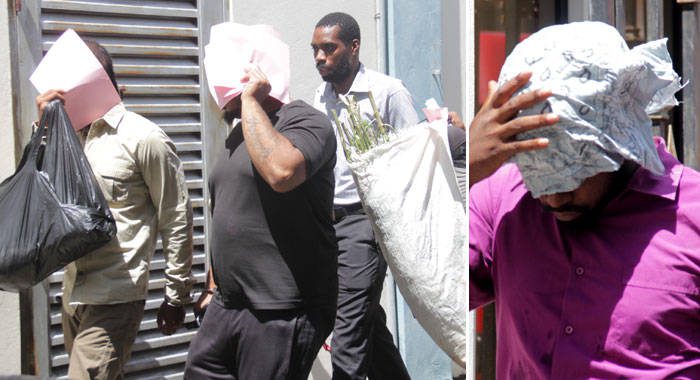 The accused men hide their faces as they are escorted to court on Thursday. (iWN photo)