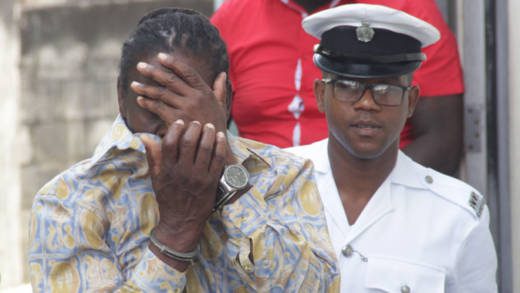 Sealey Matthias hides his face as he is escorted to prison last week Tuesday. (iWN photo)