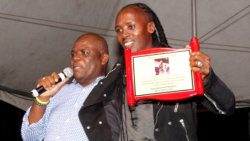 MP for North Leeward, Roland "Patel" Matthews, left, presents a plaque to soca artiste Delroy "Fireman" Hooper in their home village, Petit Bordel on Sunday. (iWN photo)
