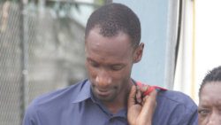 Able Body Seaman 390 Andre Samuel holds down his head outside the Serious Offences Court, in Kingstown, after making bail on a sex charge on Dec. 19, 2019. (iWN photo)