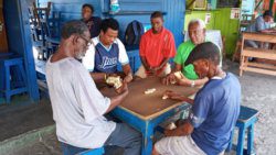 Men play dominoes in Chinatown, Kingstown. (iWN photo)