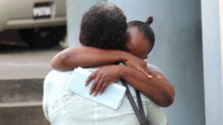The defendant's mother, with back to camera, embraces her outside the Kingstown Magistrate's Court after Monday's sentencing hearing. (iWN photo)