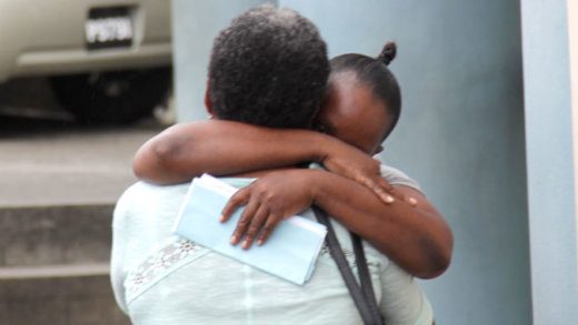 The defendant's mother, with back to camera, embraces her outside the Kingstown Magistrate's Court after Monday's sentencing hearing. (iWN photo)