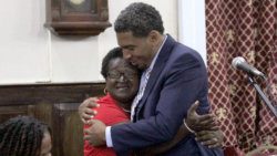 An unidentified woman who listened to the Budget Address embraces Minister of Finance Camillo after his the speech on Monday. (iWN photo)