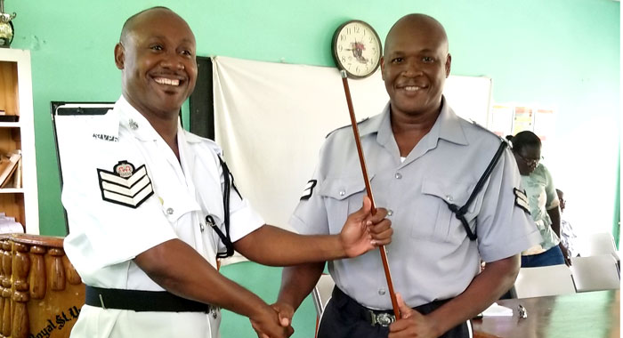 Station Sergeant Brenton Smith, left, symbolically hands over the chairmanship to his successor, Corporal Lez Harry.