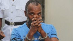 Warren Campbell uses his hands to obscure his face outside the Serious Offences Court on Tuesday. (iWN photo)
