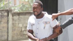 Police officers restrain murder accused Jamala John outside the Serious Offences Court on Wednesday. (iWN photo)