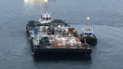 A barge brings supplies to the cruise ship off Australia. 