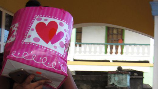 The accused, Nadia Lawrence uses a bag to hide her face as she leaves the Georgetown Magistrate's Court on Monday. (iWN photo)