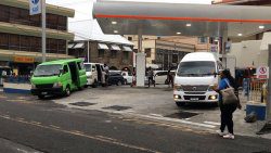 Three vans solicit passengers at the Banfield Service Station in Kingstown last Friday. (iWN photo)