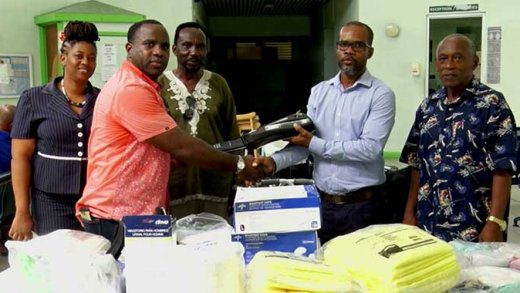 Pastor Othneil James makes the presentation to Deputy Hospital Administrator Andrew Williams on behalf of Agents of Change Organisation Inc. 