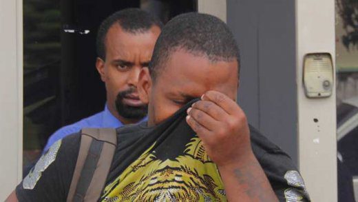 The accused, Jason Delplesche hides his face as he leaves the Kingstown Magistrate's Court on Monday. (iWN photo)
