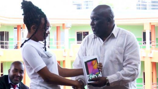 Nyla Samuel of the Division of Arts, Sciences and General Studies receives her table from Minister of Education, St. Clair “Jimmy” Prince. 

