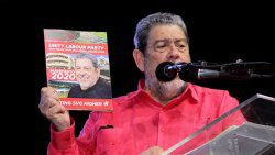 Prime Minister Ralph Gonsalves holds up a copy of the ULP's manifesto at the launch on Sunday. (iWN photo)