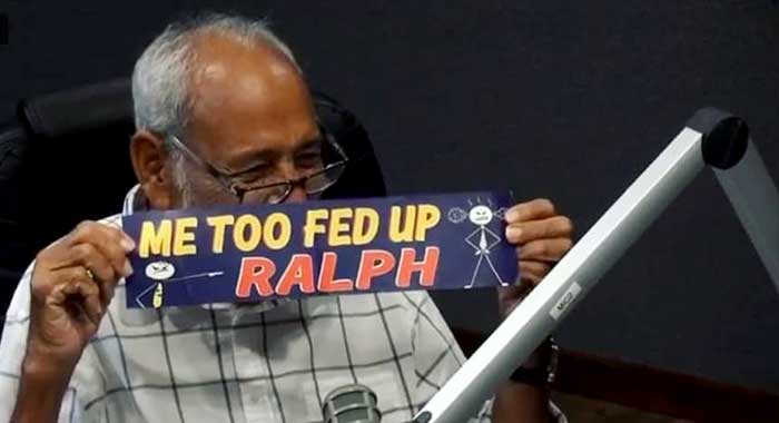 Former prime minister, Sir James Mitchell holds up a bumper sticker on Boom FM on Oct. 13. (Photo: Boom FM/Facebook) 