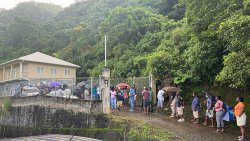 Voters ques up in light rain ahead of the 7 a.m. opening of polls in Rillan Hill, South Leeward, Thursday morning. (iWN photo)