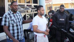 Detective Sergeant Biorn Duncan, left, escorts accused murderer Veron Primus from the Kingstown Magistrate's Court, on Monday, amidst increase police presence. (iWN photo)