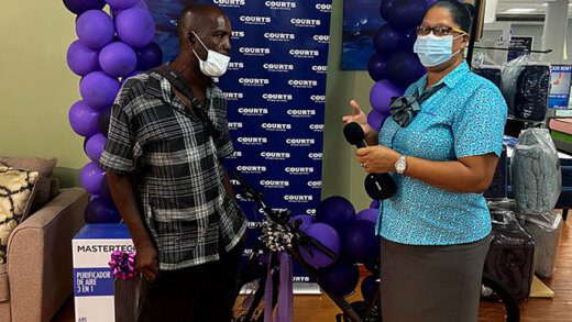 Theft victim Marcus Young, right, recieve a new bicycle from Wendy Edwards of Courts on Tuesday.
