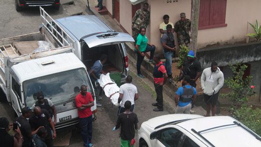 Funeral home workers place Gleason Lewis' body in a vehicle at the scene on April 26, 2020, as police officers look on. (iWN photo)