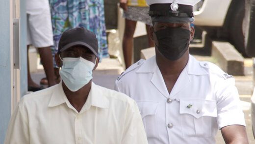 Louie Cupid in police custody outside the Serious Offences Court on Tuesday. (iWN photo)