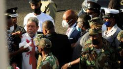 Commissioner of Polcie, Colin John, left, and other police officer around Prime Minister Ralph Gonsalves, his shirt covered in blood, after being injured in protest in Kingstown last week Thursday. (Photo: REUTERS/Robertson S. Henry)