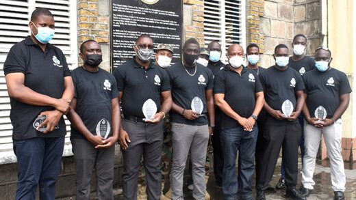 The 10 officers pose with Commissioner of Police, Colin John.