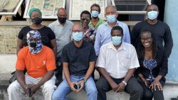 

The eight accused along with Opposition Leader Godwin Friday, standing second from right, and lawyer Shirlan "Zita" Barnwell, seated front right, outside the Kingstown Magistrate's court on Nov. 22, 2021. (iWN Photo) 