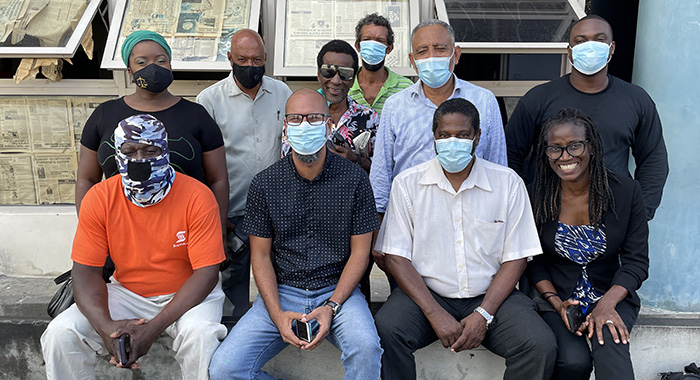 

The eight accused along with Opposition Leader Godwin Friday, standing second from right, and lawyer Shirlan "Zita" Barnwell, seated front right, outside the Kingstown Magistrate's court on Nov. 22, 2021. (iWN Photo) 