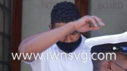 Keithron Mills hides his face as he leaves the Serious Offences Court on Friday, Jan. 28, 2022 on his way to prison for possession of an unlicensed firearm.