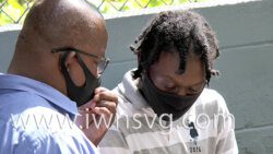 Ozem Oliver, right, speaks with an unidentified man outside the Serious Offences Court as he awaits transportation to prison on Wednesday, Jan. 19, 2022.