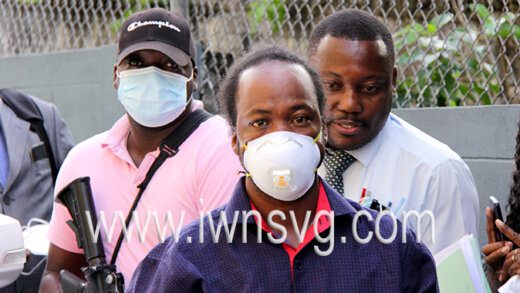 The defendant, Joloney David, centre, is escorted to court on March 9, 2022.