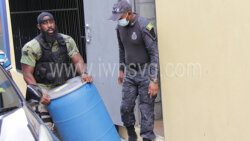 Police officers remove the barrel which is said to contain the cocaine from the Serious Offences Court on Wednesday, April 27, 2022.