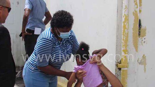 Lawyer Grant Connell looks on as Maruth Francois lifts up her daughter outside the Mesopotamia Magistrate's Court after being handed a suspended prison sentence on Friday, May 27, 2022. 