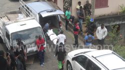 Funeral home workers remove the body of Gleason Lewis from the scene in Campden Park on April 26, 2020.