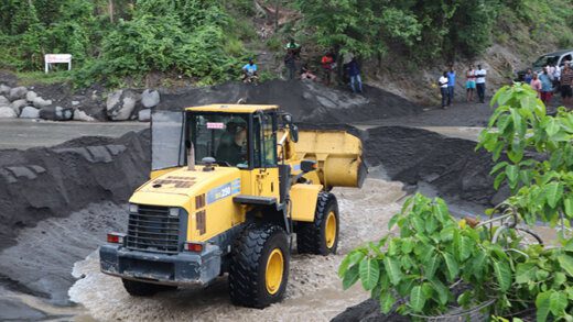 A tractor removes debris from Overland River after a recent downpour. 