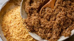 Soft brown dark sugar and unrefined sugar cane in bowls