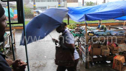 A pedestrian uses and umbrella amidst a heavy downpour in Kingstown on Tuesday, Sept. 20, 2022.