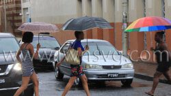 Pedestrians use umbrellas during a break in heavy rain in Kingstown on Sept. 29, 2022. More rain and high winds are expected across St. Vincent and the Grenadines this week. 