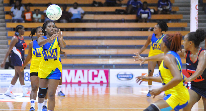 SVG wing attack and captain Ruthann Williams makes a pass to her goal attack Shellisa Davis in the game against Cayman Islands