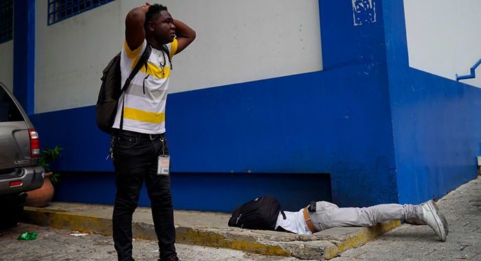 Haitian journalist Romélson Vilcin, who was fatally wounded lies face down inside the parking lot of a police station, in Port-au-Prince, Haiti, Sunday, Oct. 30, 2022. Vilsaint died Sunday after being shot in the head when police opened fire on reporters demanding the release of one of their colleagues who was detained while covering a protest, witnesses told The Associated Press. (AP Photo) (Uncredited/AP)