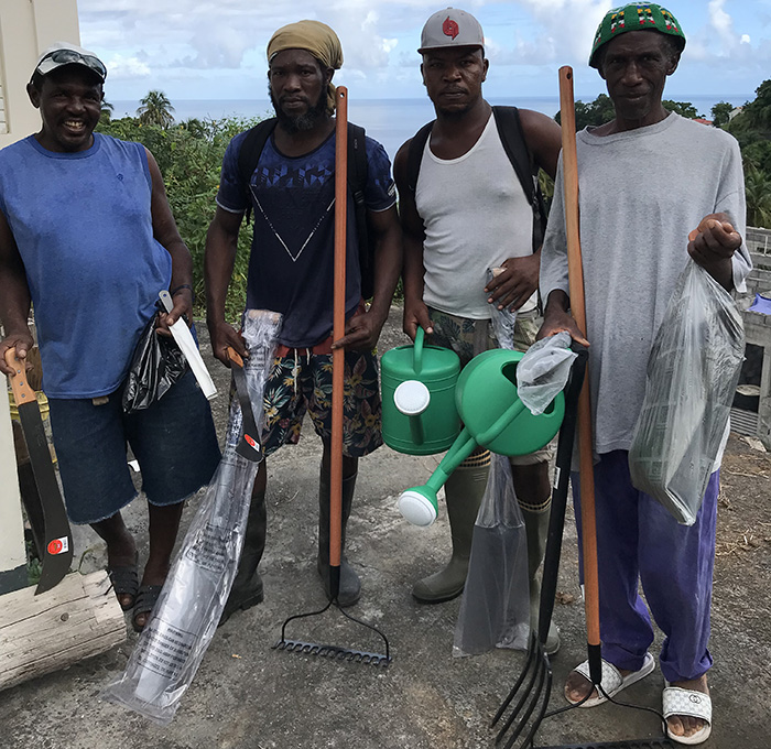 Four of the 22 farmer participants show tools they received through the project in Coulls Hill