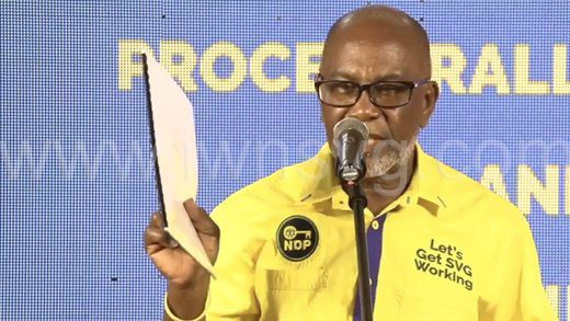 MP for Central Kingstown, St. Clair Leacock holds up the report on PetroCaribe at the NDP's public meeting on March 23, 2023.
