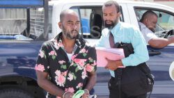 The accused, Jamal Benjie, left, is escorted to Mesopotamia Magistrate's Court by detective Corporal 339 Laborde on Friday, April 28, 2023. 