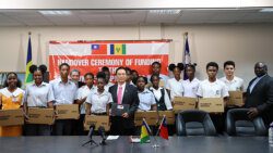 Taiwan Ambassafor to SVG, Peter Lan, centre, Prime Minister Ralph Gonsalves, left, and Minister of Education Curtis King, pose with students who received their laptops at the presentation ceremony in Kingstown, on Friday, May 26, 2023.
