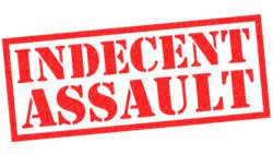 INDECENT ASSAULT red Rubber Stamp over a white background.