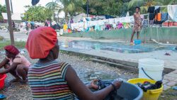 A woman displaced by Violence in the Haitian capital, Port-au-Prince washes clothes in a city park. (Photo: UNICEF)