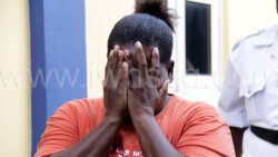 The accused, Josette Garraway hides her face outside the Serious Offences Court, in Kingstown on Monday, Sept. 11, 2023. 